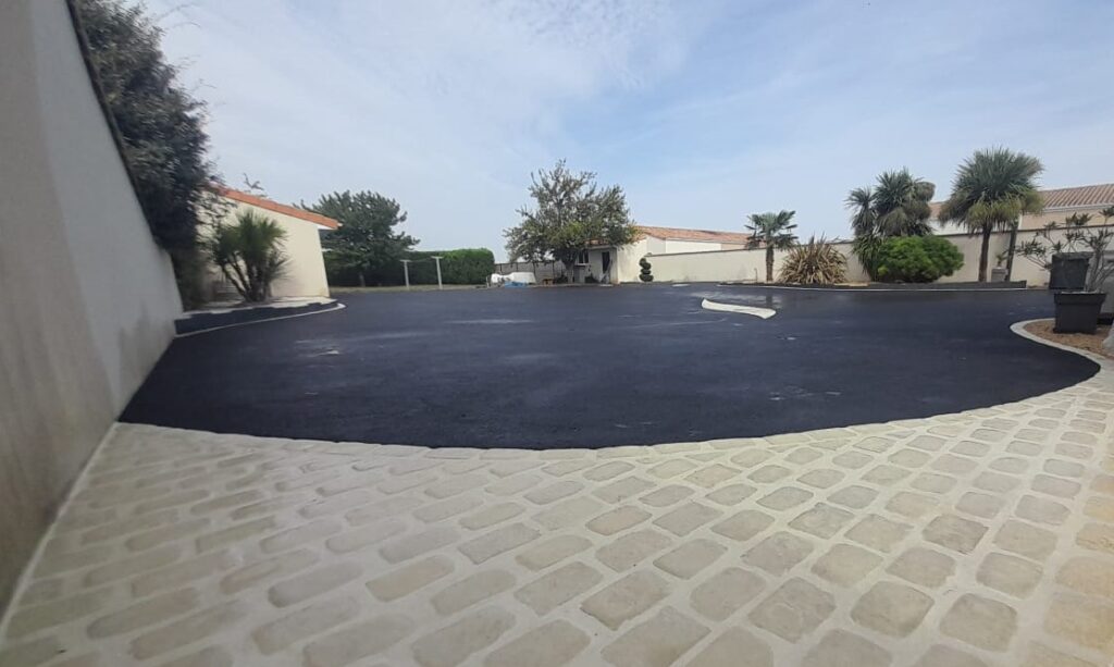 Décapage, pose de panneaux d’ardoise, posé de pavés en chaînette et en tapis, mise en place de l’enrobé à chaud noir.